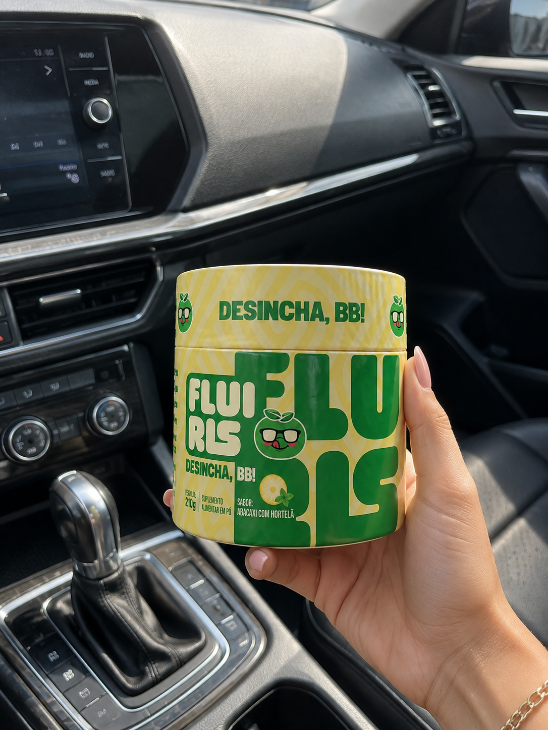 Pote de Fluiris en la mano dentro del auto